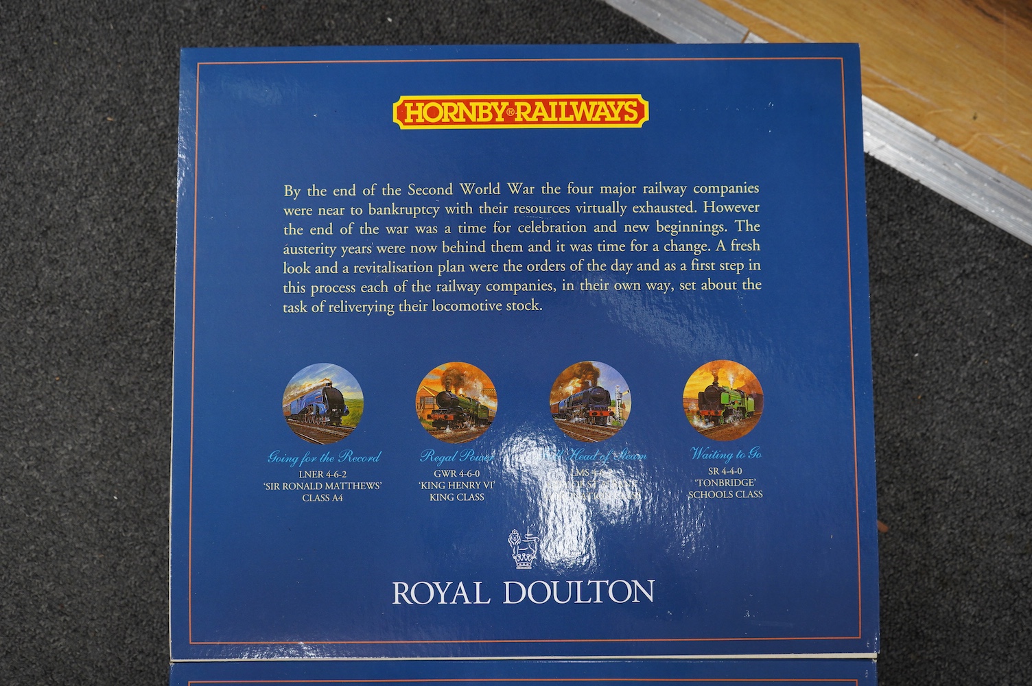 Four boxed Hornby Railways 00 gauge train packs in collaboration with Royal Doulton; an LMS Coronation Class locomotive (R459), an SR Schools Class locomotive (R648), and two GWR King Class locomotives (R650). Condition